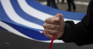 Την ελληνική σημαία κρατάει στα χέρια του ο Διαδηλώτης